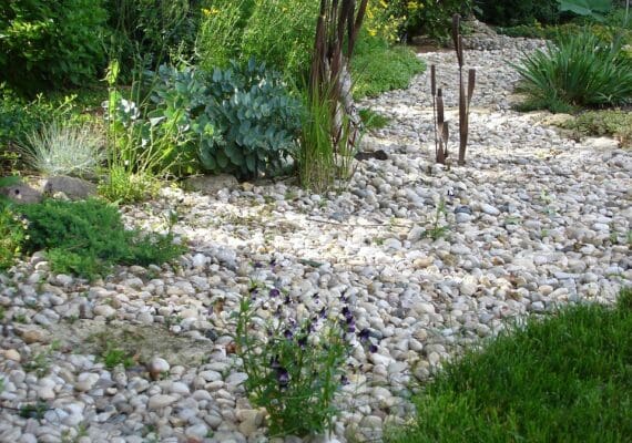 Best landscaping services in Macomb featuring dry creek bed and garden